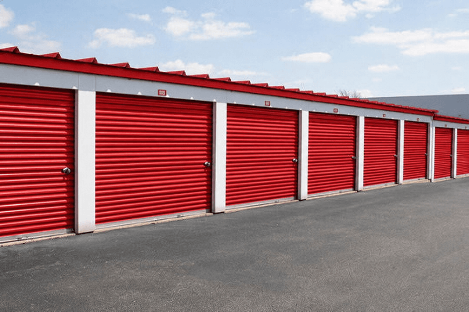 Row of storage units with red roll-up doors